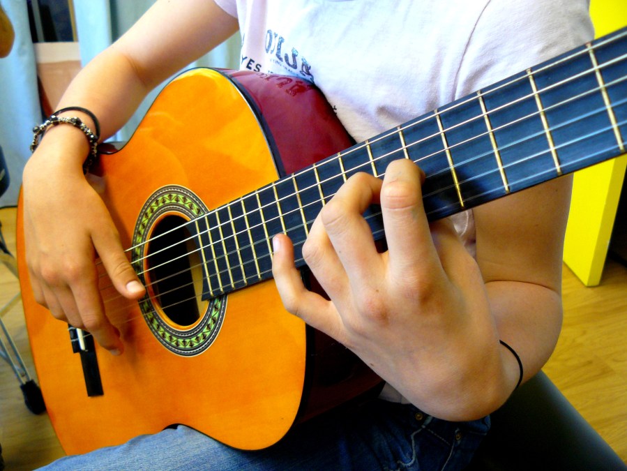 Gros plan sur les mains d'une guitariste classique