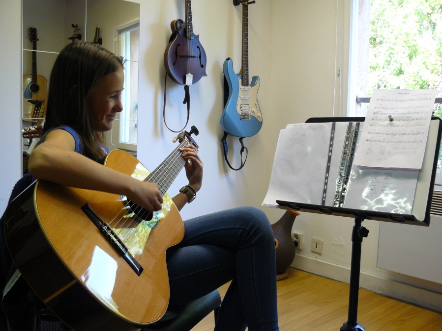 Elève travaillant un morceau de bossa nova à la guitare